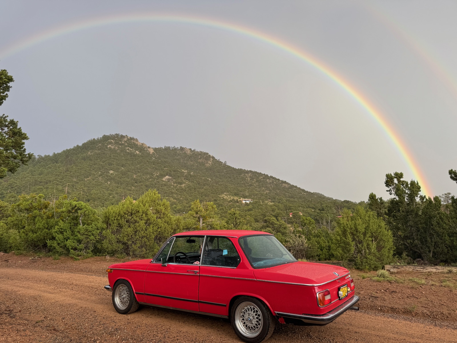 BMW 2002tii under a double rainbow in the New Mexico mountains