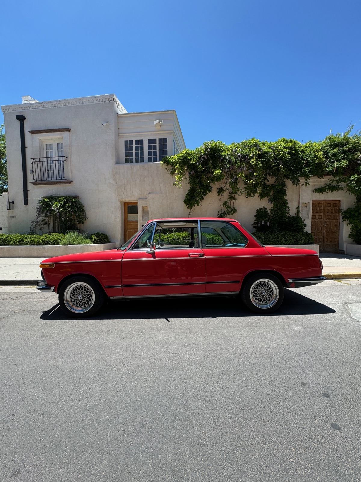 1974 BMW 2002tii — side profile against stucco wall, Santa Fe