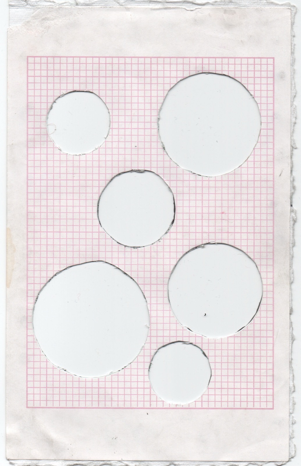 Zine spread — die-cut circles in pink graph paper, peephole motif